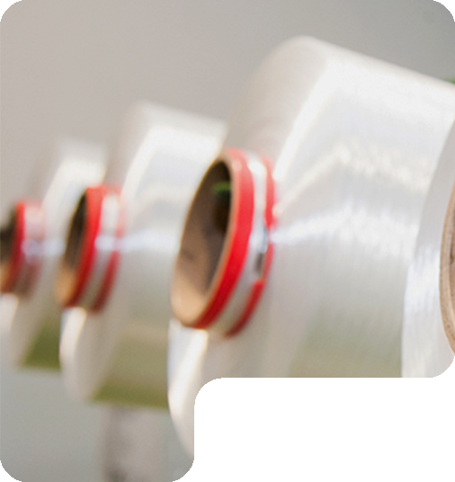 Gulungan benang polyester putih pada mesin pemrosesan benang sebagai bahan baku pembuatan tali