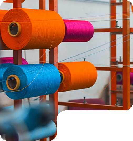Gulungan benang PP (Polypropylene) Multifilament warna oranye muda, biru tomi, dan pink stabilo sebagai bahan baku produksi talikur